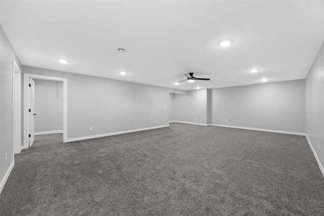 basement with dark colored carpet and ceiling fan