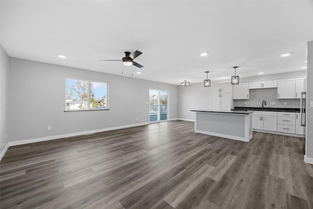 kitchen featuring white cabinets, hanging light fixtures, dark hardwood / wood-style floors, ceiling fan, and a kitchen island