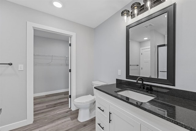 bathroom featuring vanity, toilet, and wood-type flooring