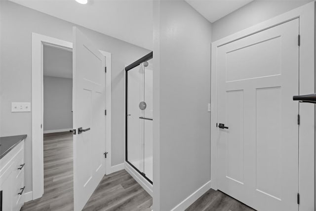 bathroom featuring hardwood / wood-style flooring and walk in shower