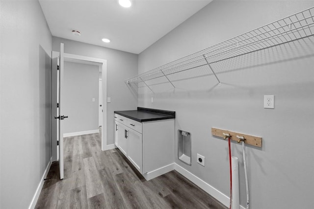 washroom with electric dryer hookup, dark hardwood / wood-style flooring, and hookup for a washing machine