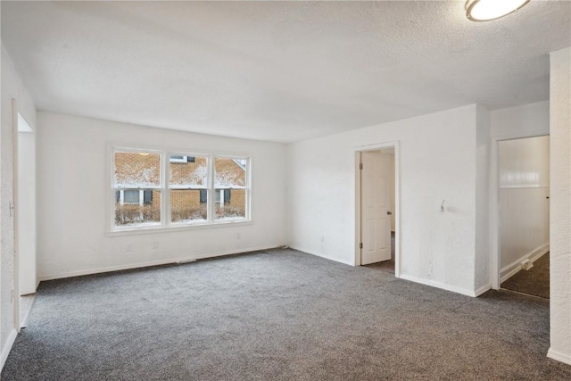 carpeted empty room featuring a textured ceiling