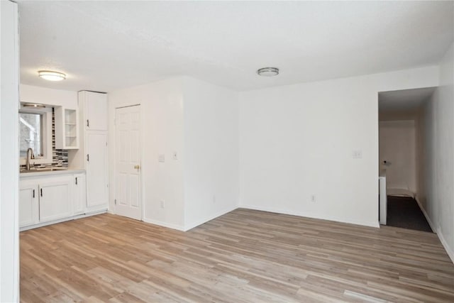 unfurnished room featuring light wood-type flooring and sink