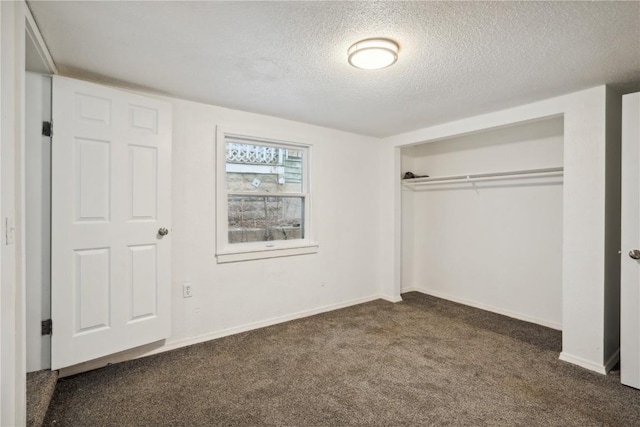 unfurnished bedroom featuring a closet, a textured ceiling, and dark colored carpet