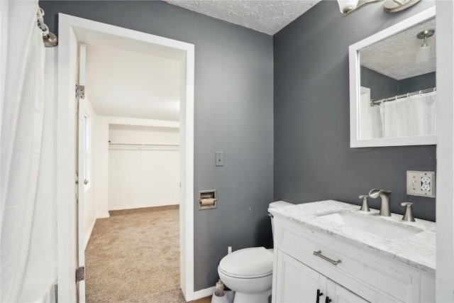 bathroom featuring vanity, a textured ceiling, and toilet