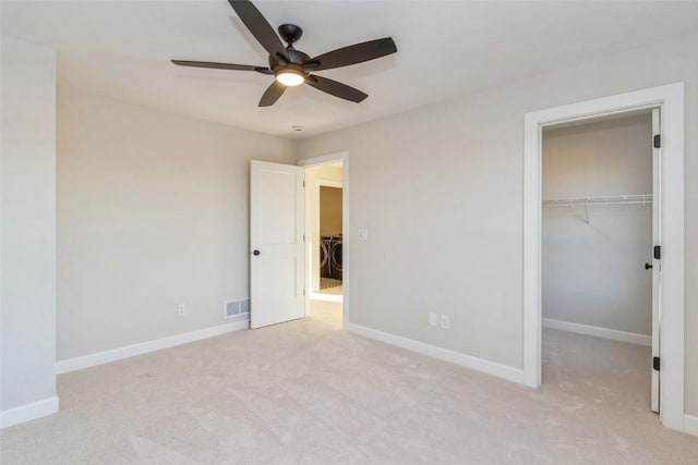 unfurnished bedroom featuring ceiling fan, light colored carpet, and a closet