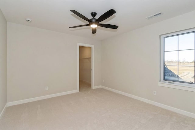 empty room with ceiling fan and light colored carpet