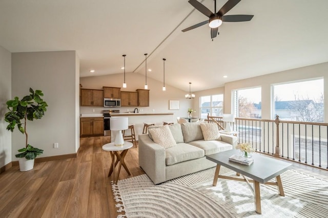 living room featuring ceiling fan, wood-type flooring, and lofted ceiling