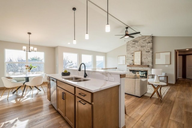 kitchen with ceiling fan with notable chandelier, sink, decorative light fixtures, dishwasher, and lofted ceiling