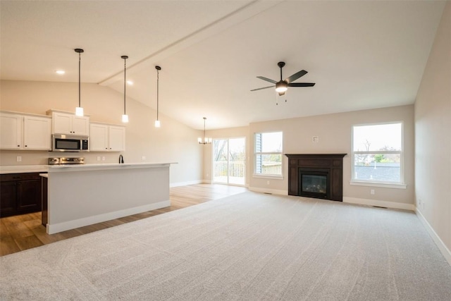 1913 Holly Meadow Ave SW, Cedar Rapids, IA 52404 - unfurnished living room with a glass covered fireplace, plenty of natural light, ceiling fan, a chandelier, and beam ceiling