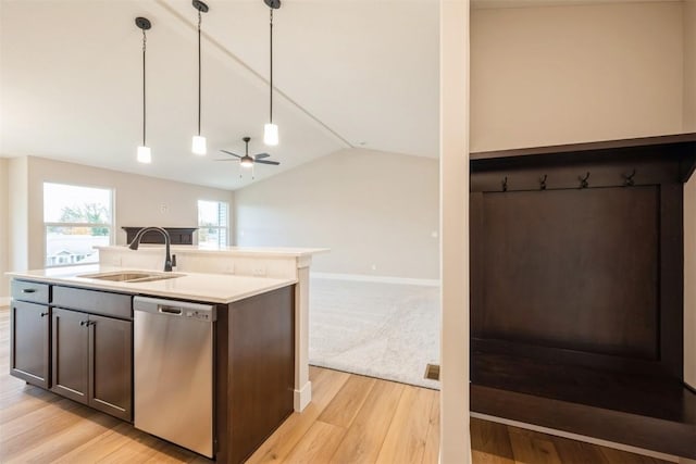 kitchen featuring a sink, light wood-style floors, open floor plan, vaulted ceiling, and stainless steel dishwasher