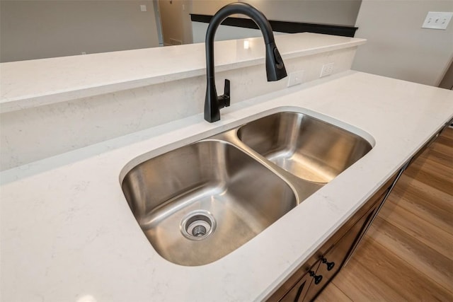 room details with light countertops, a sink, and wood finished floors