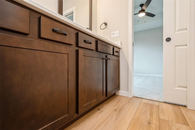 interior space with baseboards, a ceiling fan, and wood finished floors