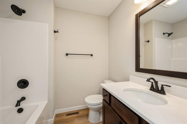 bathroom with baseboards, visible vents, toilet, and wood finished floors