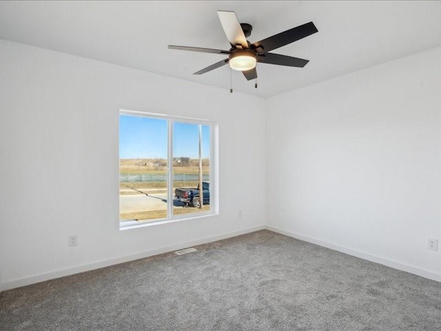 spare room with ceiling fan and carpet