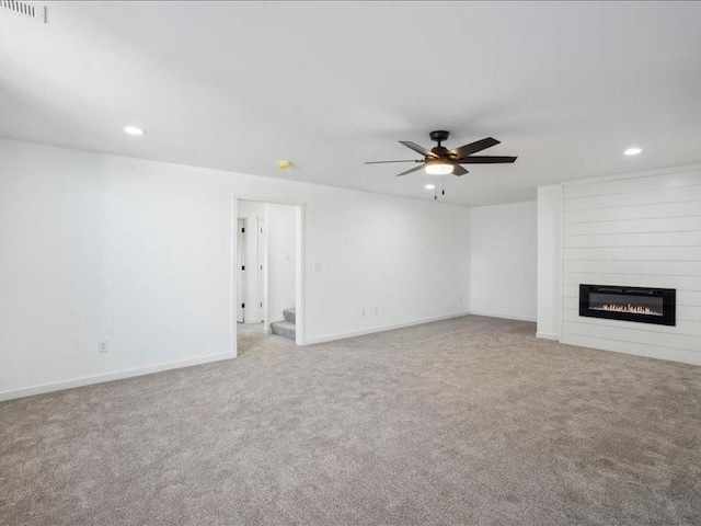 unfurnished living room with carpet, ceiling fan, and a fireplace