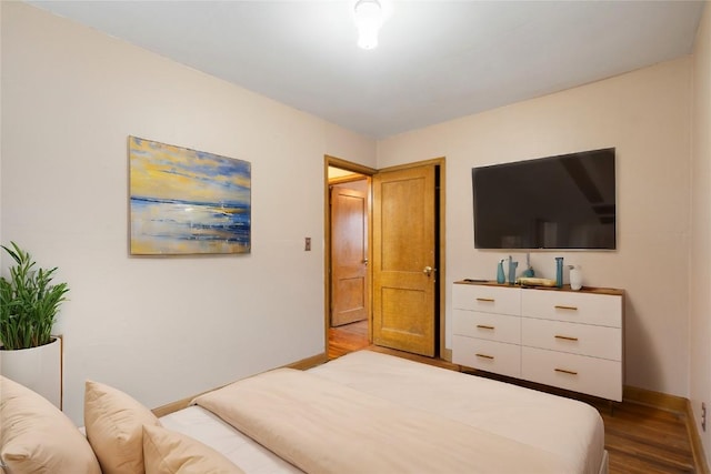 bedroom featuring baseboards and wood finished floors