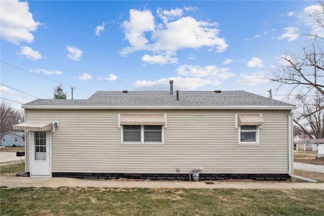 rear view of property featuring a shingled roof