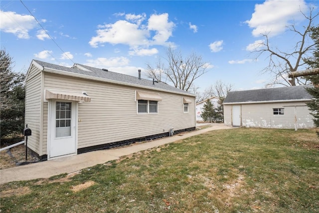 rear view of house with an outbuilding and a lawn