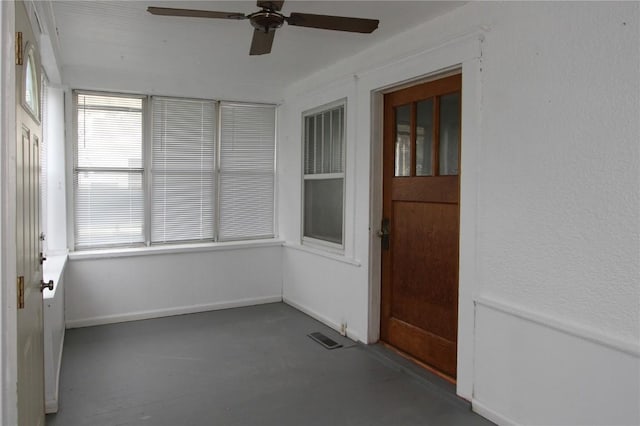 unfurnished sunroom with ceiling fan