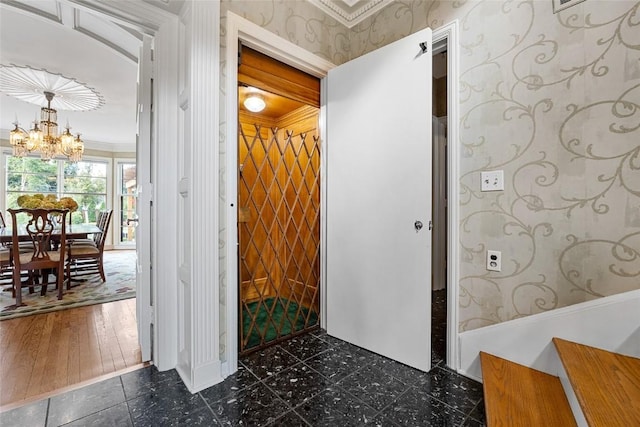 interior space featuring dark hardwood / wood-style floors, crown molding, and a notable chandelier