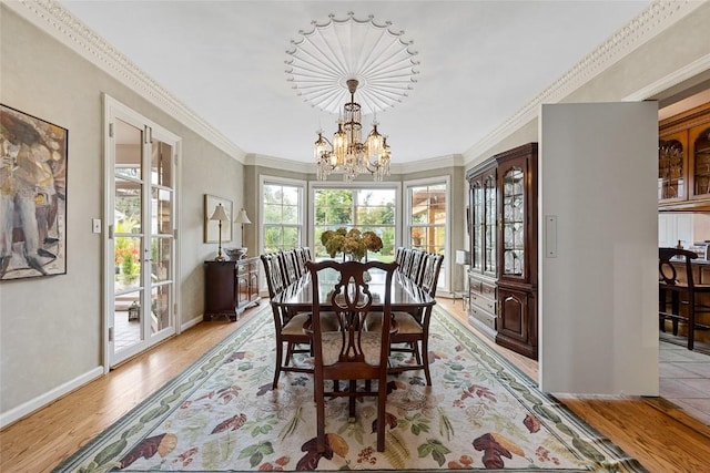 dining area featuring light hardwood / wood-style floors, crown molding, and a notable chandelier