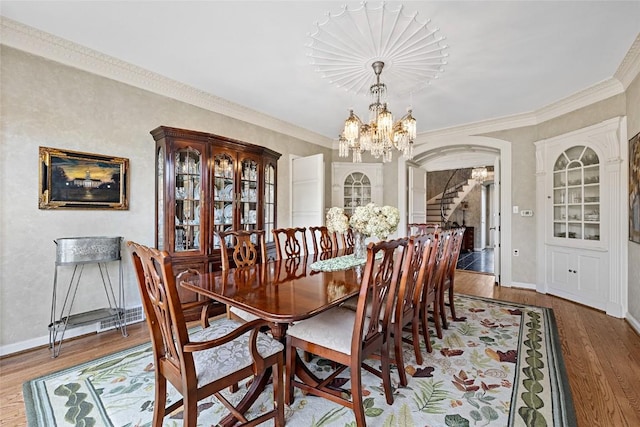 dining room featuring hardwood / wood-style floors, an inviting chandelier, and ornamental molding