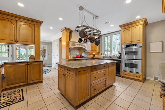 kitchen featuring light stone countertops, a kitchen island, light tile patterned flooring, and appliances with stainless steel finishes