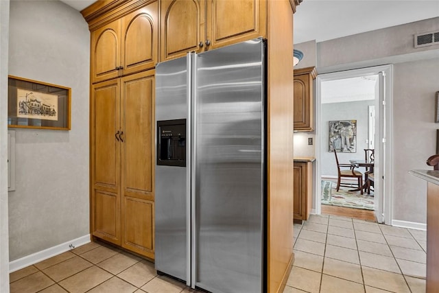 kitchen with stainless steel refrigerator with ice dispenser and light tile patterned flooring