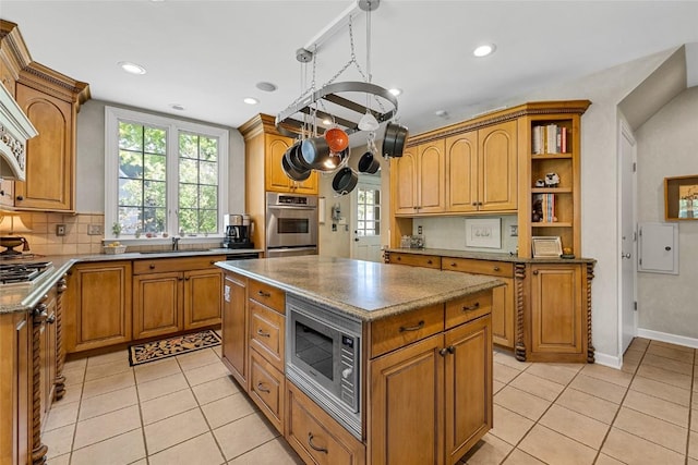 kitchen with pendant lighting, a center island, light tile patterned floors, and appliances with stainless steel finishes