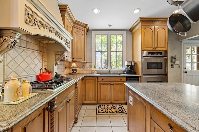 kitchen featuring backsplash, custom exhaust hood, a healthy amount of sunlight, and stainless steel appliances