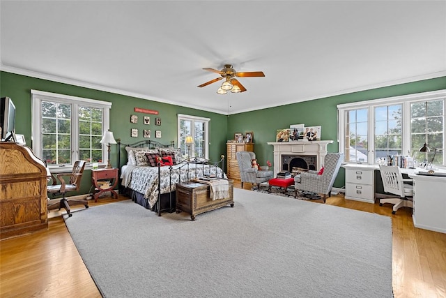 bedroom with light hardwood / wood-style floors, ceiling fan, and crown molding