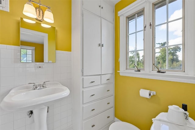 bathroom with a healthy amount of sunlight and tile walls