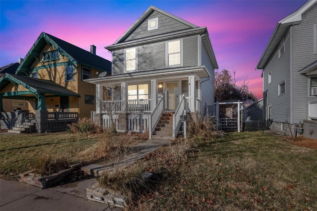 front facade with a porch and a yard