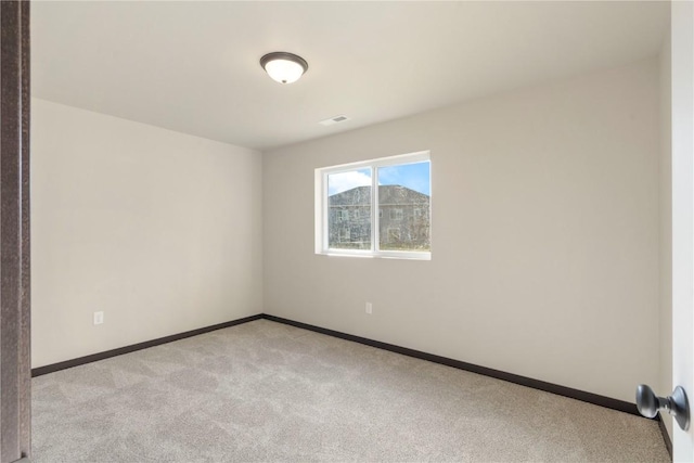 unfurnished room with baseboards, visible vents, and light carpet