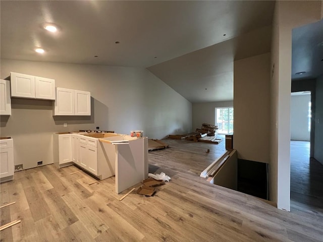 kitchen with white cabinets, open floor plan, and light wood finished floors