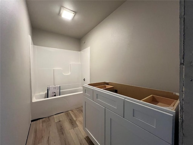 full bath featuring wood finished floors and bathtub / shower combination