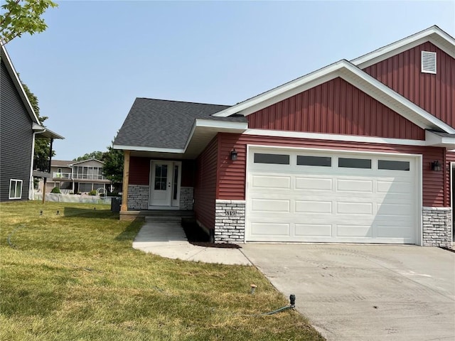 819 Prairie View Dr, West Branch, IA 52358 - view of front facade featuring driveway, a garage, stone siding, a front lawn, and board and batten siding