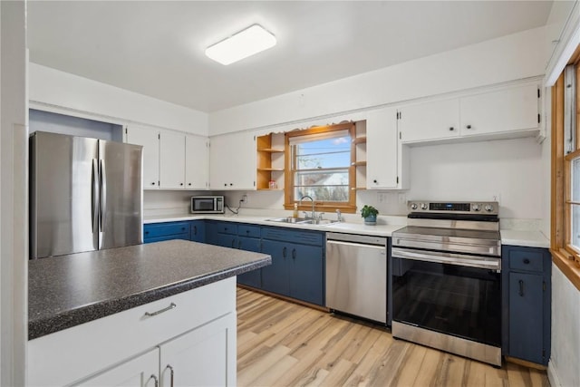 kitchen featuring light hardwood / wood-style floors, white cabinetry, stainless steel appliances, and blue cabinets