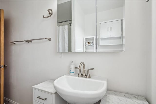 bathroom featuring curtained shower and sink