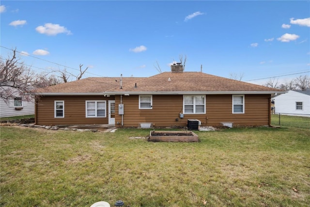 rear view of house with cooling unit and a yard