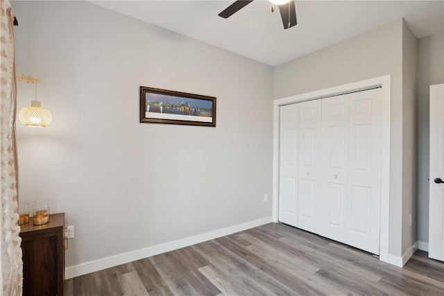 unfurnished bedroom featuring ceiling fan, wood-type flooring, and a closet