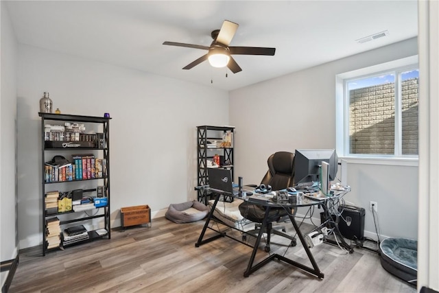 home office with wood-type flooring and ceiling fan