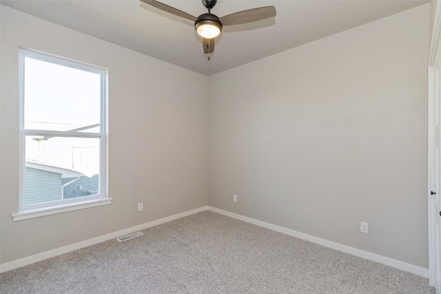 carpeted spare room featuring ceiling fan