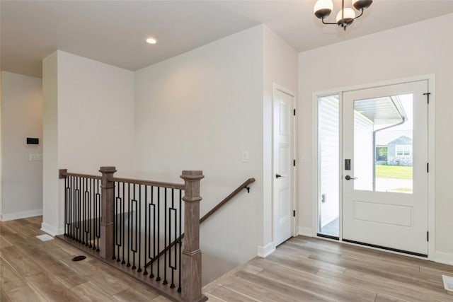 entrance foyer with light wood-type flooring and a notable chandelier