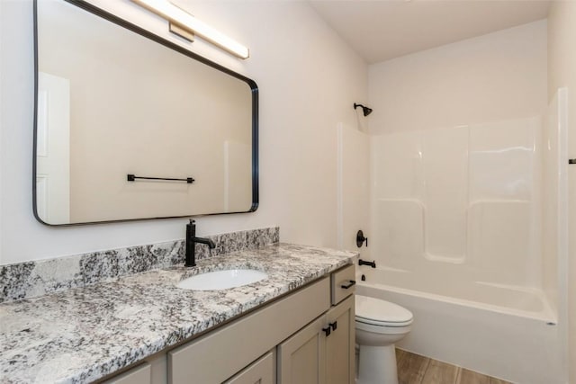 full bathroom featuring hardwood / wood-style floors, vanity, toilet, and shower / bath combination