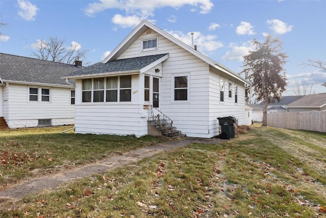 rear view of property with a sunroom and a lawn