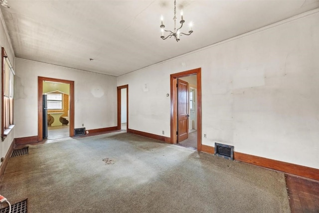 unfurnished room featuring carpet flooring, ornamental molding, and a notable chandelier