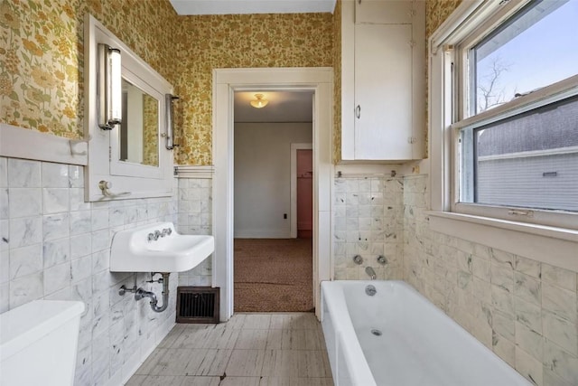 bathroom featuring a bathing tub, tile walls, and toilet