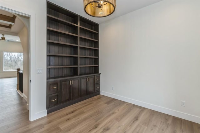 interior space with beam ceiling, light wood-type flooring, and ceiling fan